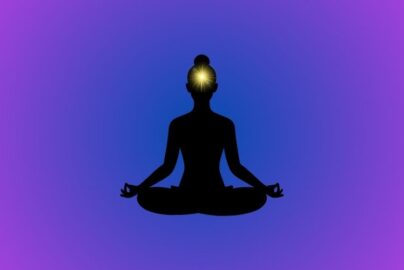 An illustration of the Ajna chakra showing a glowing indigo light at the forehead, symbolizing balanced inner vision, intuition, and spiritual awareness.