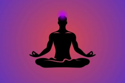 Silhouette of a person meditating in lotus position with a glowing crown chakra on top of the head, set against a purple and pink gradient background.