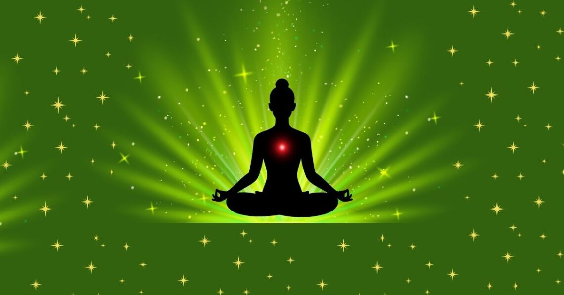 Silhouette of a person meditating with a glowing red heart chakra on a green starry background.