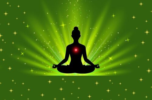 Silhouette of a person meditating with a glowing red heart chakra on a green starry background.