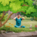 A woman practices bhramari technique outdoors in a park, sitting cross-legged under a large tree with her hands covering her eyes, surrounded by illustrated flowers and greenery.A woman practices yoga outdoors in a park, sitting cross-legged on a mat under a large tree with her hands covering her eyes, surrounded by illustrated flowers and greenery.