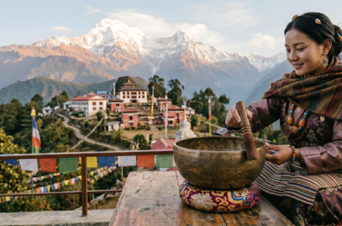 Woman playing a Tibetan singing bowl with a mallet on a terrace overlooking mountains and a monastery in Sikkim.